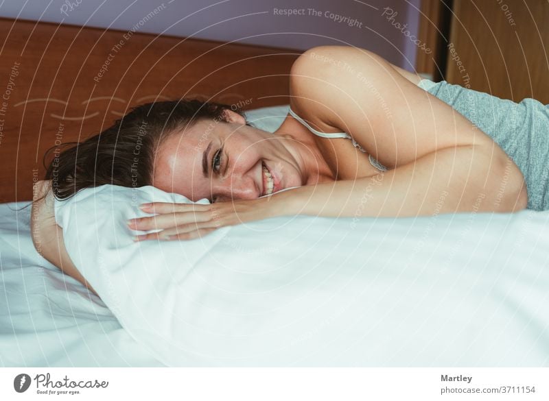 Nahaufnahme-Porträt einer lächelnden attraktiven Frau, die auf dem Bett liegt und in die Kamera schaut. Menschen Erwachsener Mädchen Raum Schlafzimmer Familie