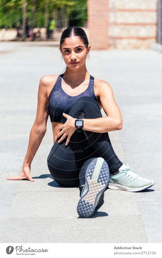 Entschlossene Frau wärmt sich auf der Straße auf Aufwärmen Dehnung Training Großstadt Sportlerin beweglich passen Sommer Athlet Sportbekleidung Wellness
