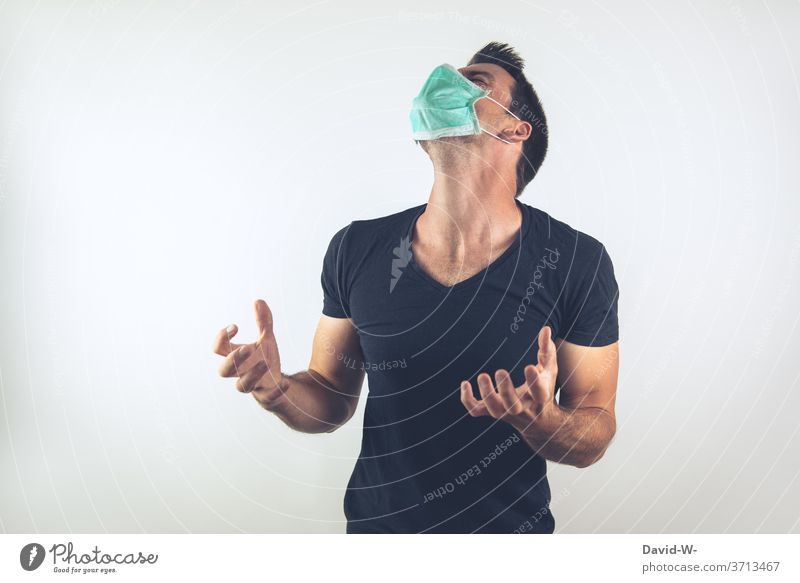 Mann mit Atemschutzmaske dreht durch Mundschutz Maskenpflicht Schutzmaske wütend aufregen genervt Corona