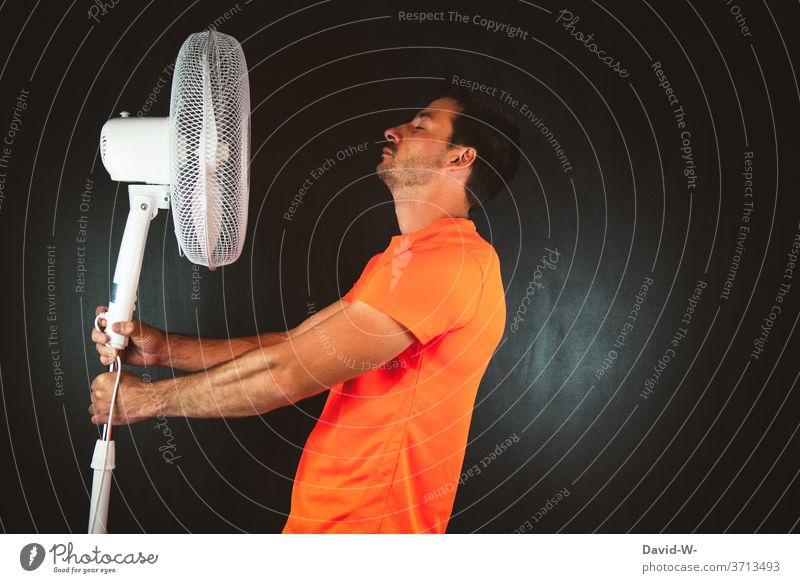 Mann hält Ventilator in den Händen hitze schwitzen warm heiß Sommer Sportler sportlich Wärme Luft