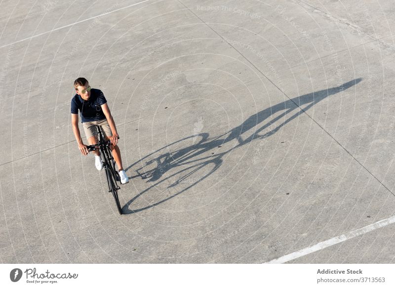 Junger Mann fährt Fahrrad auf der Straße Erwachsener blond lässig Kaukasier Textfreiraum Mitfahrgelegenheit Fahrradfahren Radfahrer Lifestyle männlich