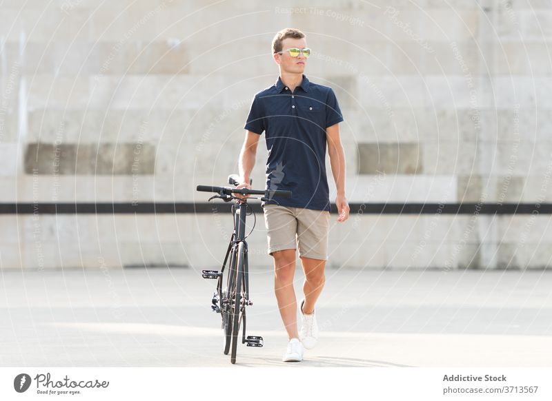 Junger Mann mit Fahrrad auf der Straße Erwachsener blond lässig Kaukasier Textfreiraum Mitfahrgelegenheit Fahrradfahren Radfahrer Lifestyle männlich