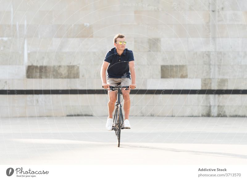 Junger Mann fährt Fahrrad auf der Straße Erwachsener blond lässig Kaukasier Textfreiraum Mitfahrgelegenheit Fahrradfahren Radfahrer Lifestyle männlich