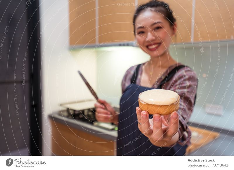 Zufriedener Bäcker zeigt leckere Torte Frau zufrieden Gebäck Sahne heimwärts Kleinunternehmen Spachtel Brotbelag heiter manifestieren Lächeln Dessert