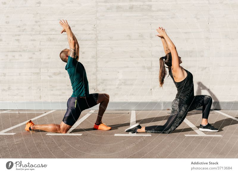 Fit Paar tun Yoga zusammen in der Stadt Sichel-Lungen-Pose Zusammensein üben Asana anjaneyasana Sportbekleidung meditieren Gesundheit Harmonie Wellness