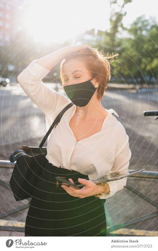 Geschäftsfrau in medizinischer Maske in der Stadt Großstadt Straße Frau Mundschutz Unternehmer behüten Coronavirus Tablette sonnig gut gekleidet Stil elegant