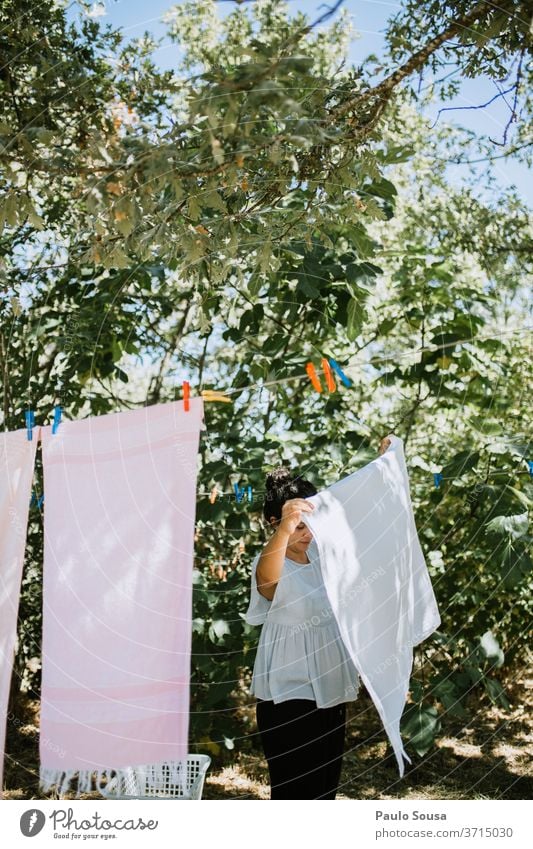 Frau hängt Kleidung an Wäscheleine Bekleidung häusliches Leben Hausfrau Hausarbeit Lifestyle aufhängen Waschtag Haushaltsführung Sauberkeit Häusliches Leben
