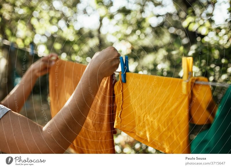 Frau hängt Kleidung an Wäscheleine Bekleidung erhängen trocknen Wäscherei gewaschen Sauberkeit Klammer Haushaltsführung Seil Außenaufnahme Waschtag