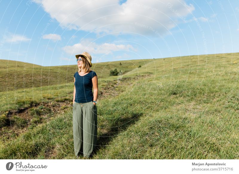 Junge Frau genießt auf den Bergwiesen Erwachsener sorgenfrei lässig Kaukasier heiter Landschaft genießen Umwelt erkunden Feld Freiheit Gras grün Fröhlichkeit
