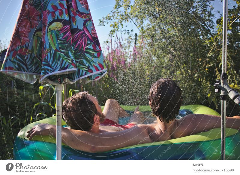 Zwei Männer im Pool wasser liebend Sommer Urlaub Urlaubsstimmung Garten grün Wasser Schwimmen & Baden Männersache Männerliebe Freundschaft blau Außenaufnahme