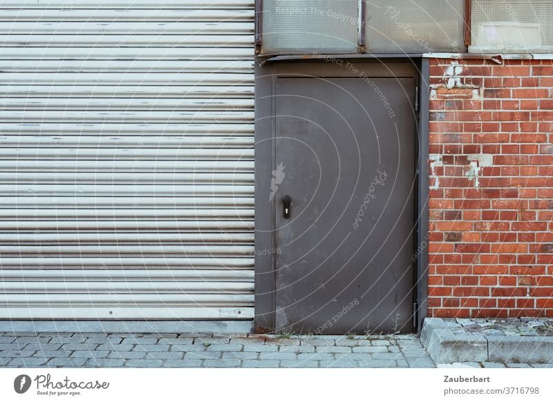 Stahltür, Tor, Ziegelmauer und blinde Scheiben einer alten Fabrik Tür Lamellen Wand Backsteine ziegelrot grau Glasscheibe Flächen geometrisch zweidimensional