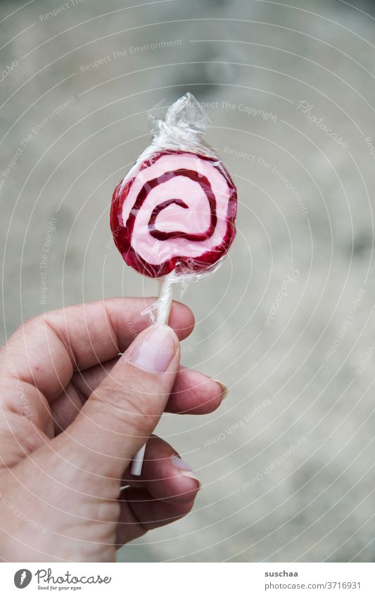 hand hält einen lolli Hand Finger Frau Lolli Lutscher Dauerlutscher Zucker süß Bonbon Lebensmittel lecker Süßwaren Lollipop Karies ungesund Spirale