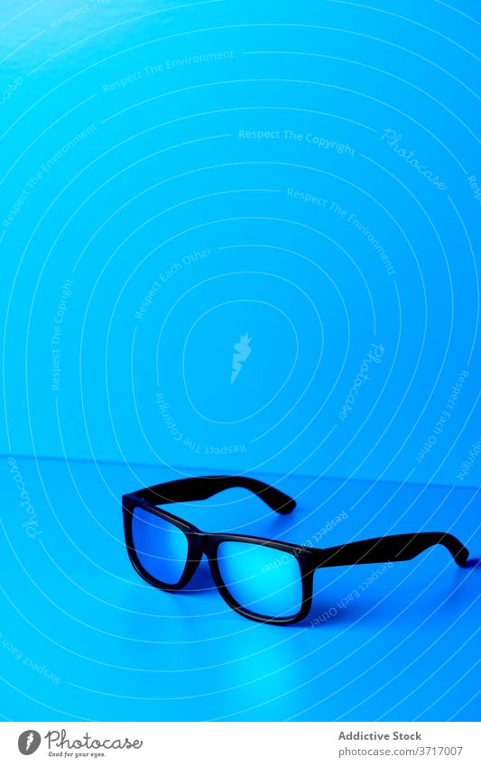 Stilvolle Brillen auf blauem Tisch Kunststoff trendy Accessoire modern Atelier kreativ Design Mode hell Sonnenbrille elegant Schreibtisch sehr wenige einfach