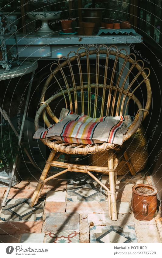 Rattanstuhl auf der Veranda mit Schatten und Sonne Stuhl Möbel Sitz Haus altehrwürdig Kissen altmodisch deco dekorativ Stil stylen Sitzgelegenheit Windstille