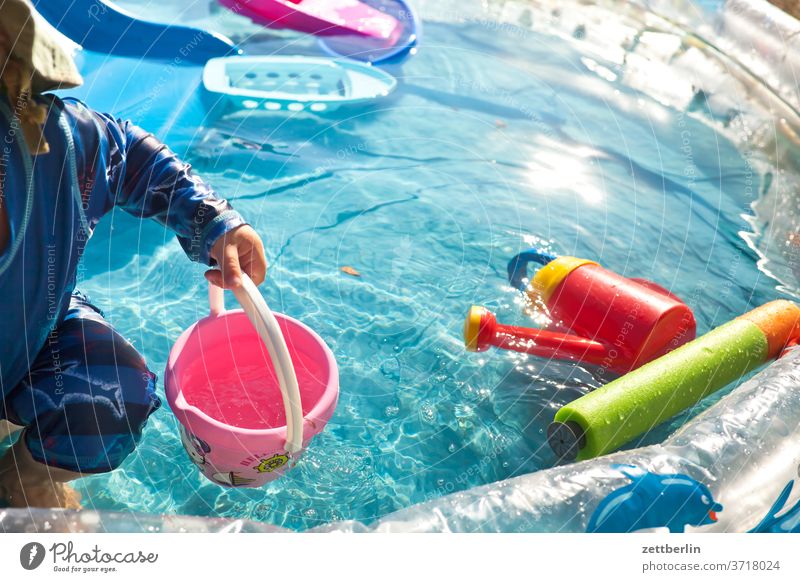 Kleines Kind im kleinen Swimmingpool pool swinningpool becken wasser wasserbecken planschbecken baden sommer hochsommer hitze spiel spielzeug wasserspielzeug