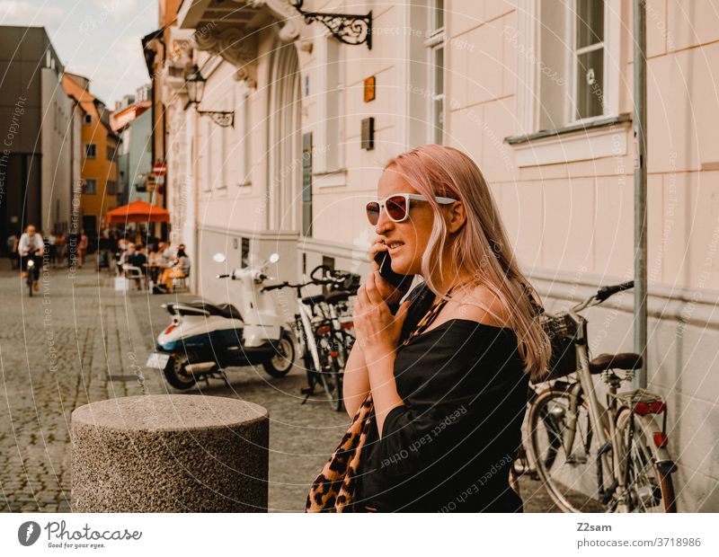Junge Frau in der Innenstadt von Regensburg beim telefonieren City regensburg bayern Seeightsing leopardenmuster sonnebrille sommer mode modedesign Farbfoto