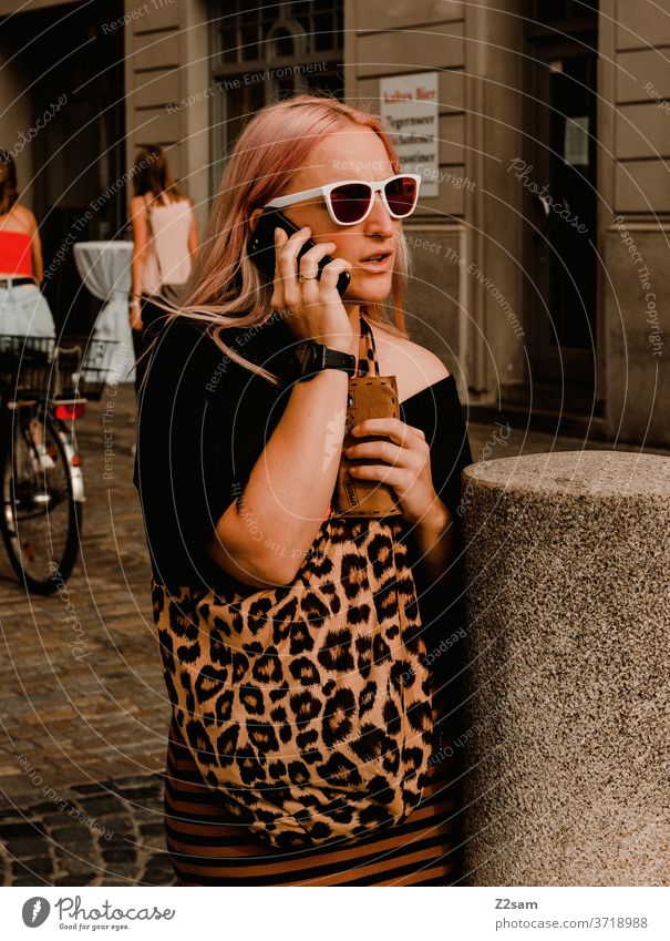 Junge Frau in der Innenstadt von Regensburg beim telefonieren City regensburg bayern Seeightsing leopardenmuster sonnebrille sommer mode modedesign Farbfoto