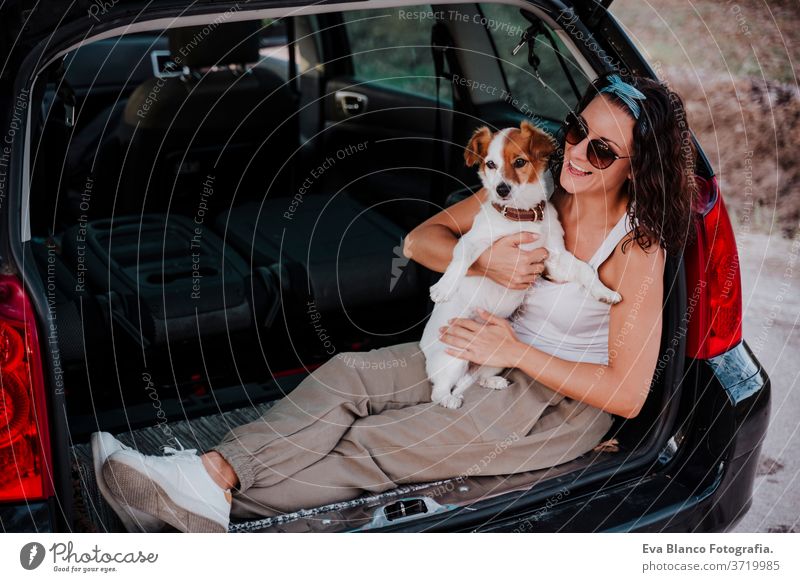 junge glückliche Frau in einem Auto, die sich mit ihrem süßen Hund vergnügt. Reisekonzept PKW reisen jack russell Zusammensein Liebe im Freien Lifestyle