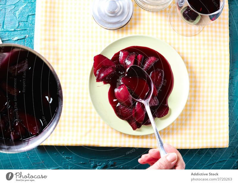 Crop-Frau am Tisch mit pochierten Birnen Rotwein süß Dessert Frucht Portion lecker trinken Lebensmittel Getränk frisch Snack Speise Mahlzeit heimwärts