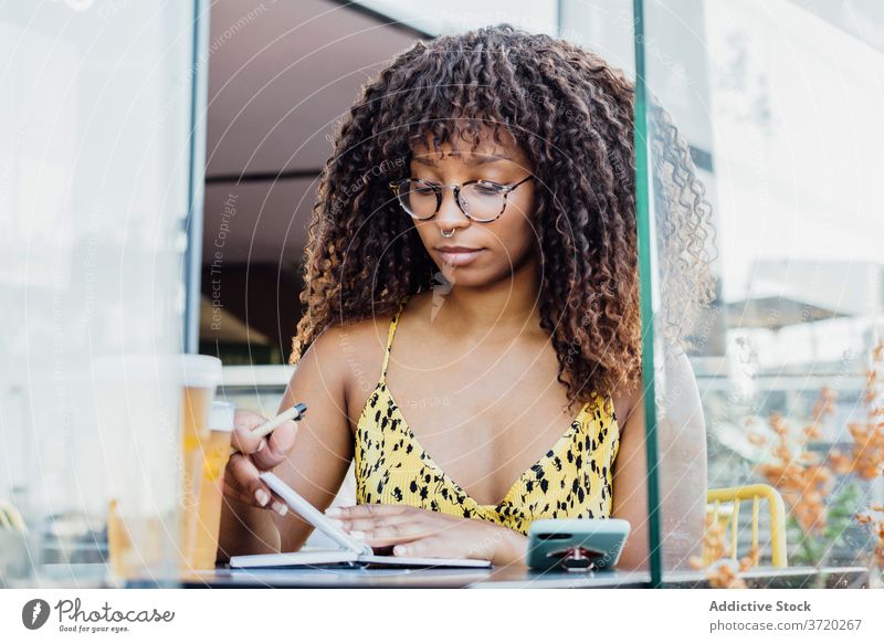 Weibliche Freiberuflerin macht sich Notizen in einem Notizbuch Frau freiberuflich Café Arbeit zur Kenntnis nehmen Notebook Unternehmer Sommer Notizblock