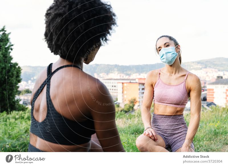 Junge Sportlerinnen mit Schutzmasken ruhen sich beim Training aus Frauen Fitness sportlich Mundschutz behüten Übung Coronavirus jung rassenübergreifend