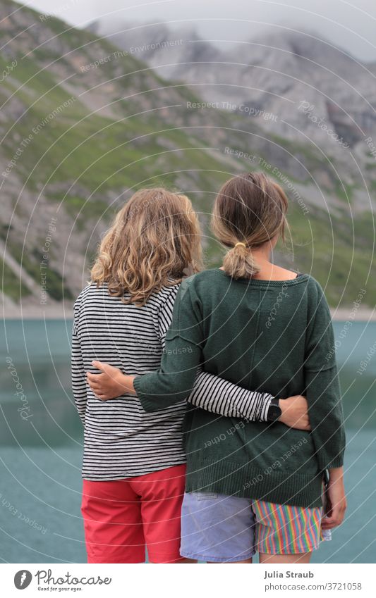 zwei Frauen halten sich im Arm am Ufer eines Bergsee`s Berge u. Gebirge Freundschaft Paar feminin gemeinsam gemeinsam erleben Natur wandern steinig See Seeufer