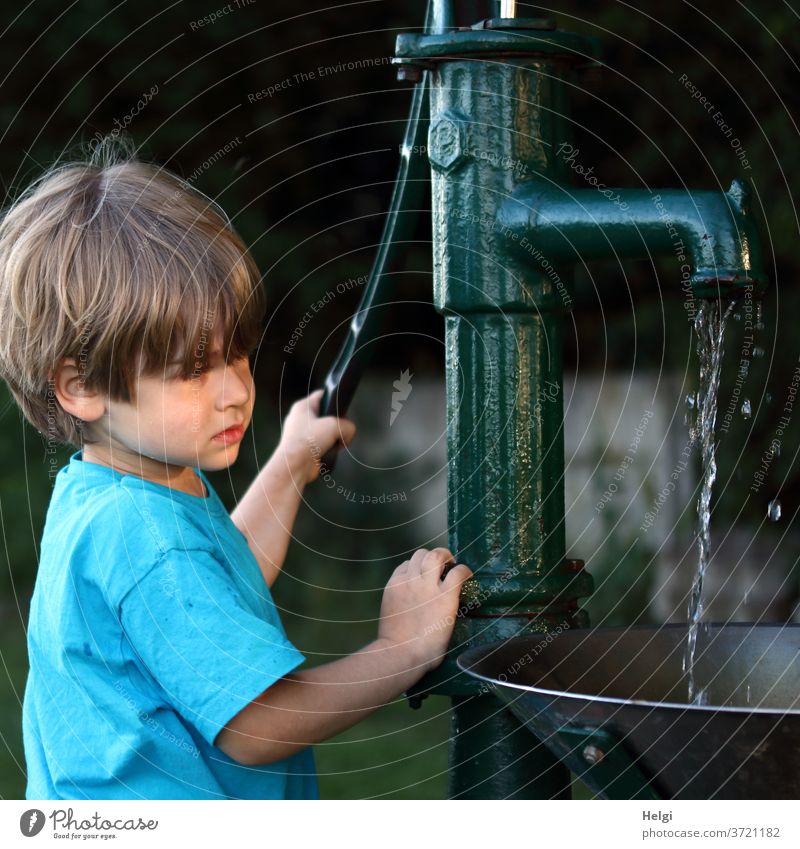 Wasser marsch! - Junge pumpt Wasser mit einer Schwengelpumpe Kind Oberkörper Pumpe Wasserpumpe alt nostalgisch pumpen Sonnenlicht Abendsonne Licht Schatten
