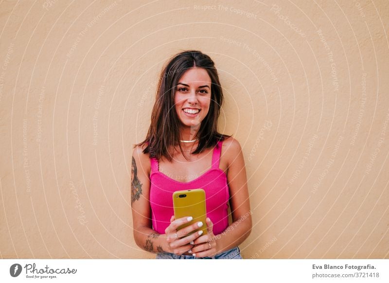 schöne junge Frau im Freien, die ein Foto mit einem Mobiltelefon macht. Technologie und Lebensstil Handy Straße urban Lifestyle Lächeln Großstadt