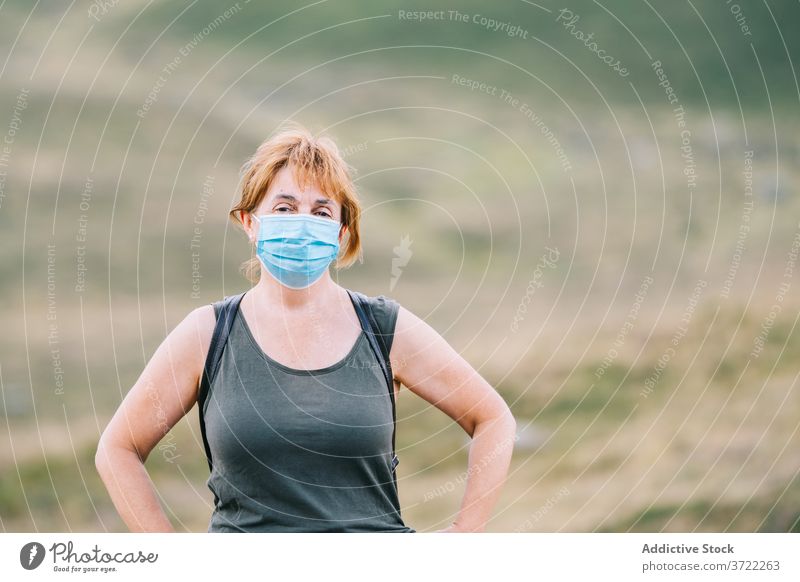 Reisende Frau, die sich eine medizinische Gesichtsmaske aufs Gesicht setzt verhindern messen Ausflug 50s sicher erkunden Pandemie Prävention Seuche behüten
