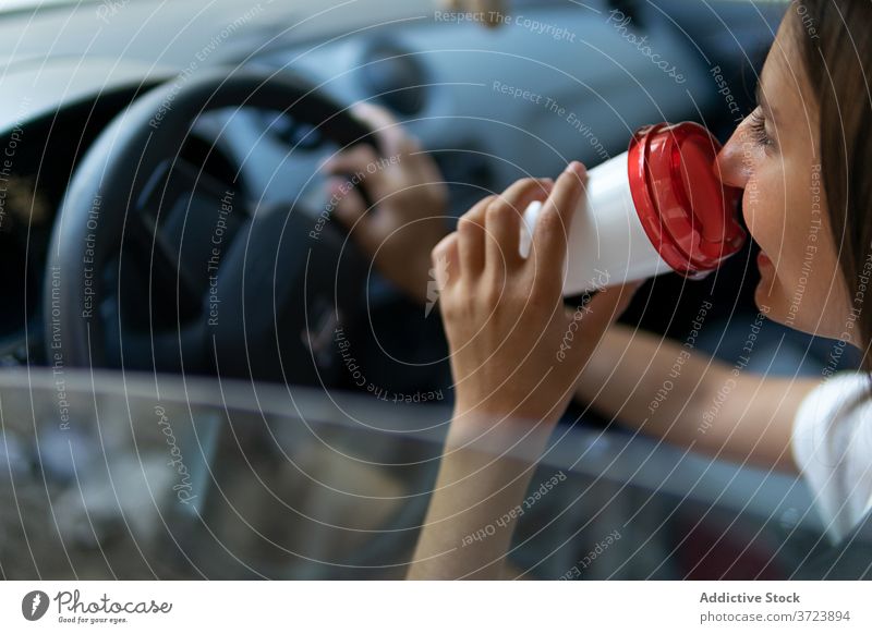 Zufriedene Frau trinkt Kaffee im Auto Fahrer trinken PKW Arbeitsweg Morgen Laufwerk Imbissbude Automobil positiv Getränk zum Mitnehmen Tasse frisch modern Glück