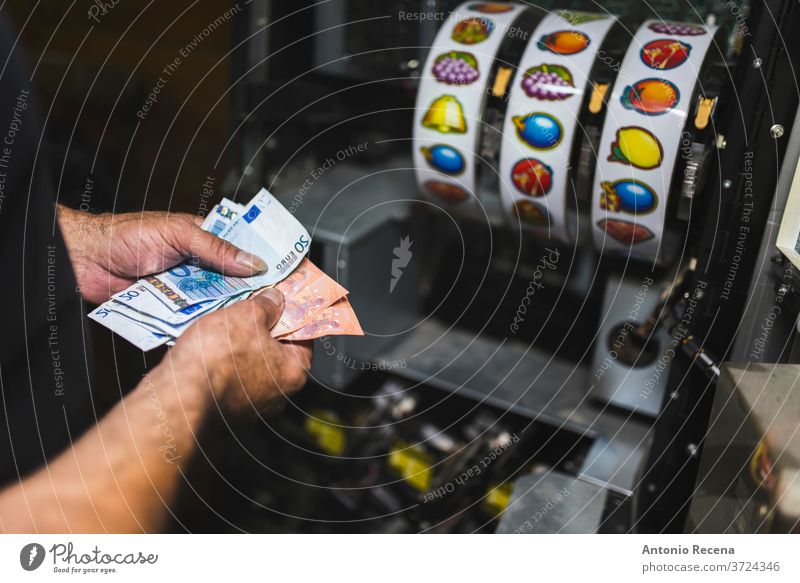 Mann sammelt Geld an Spielautomaten. Nahaufnahme des Geldautomaten. reparierend Einwurfschlitz Maschine Job Arbeit Arbeiter Laster Wirtschaft Glücksspiel