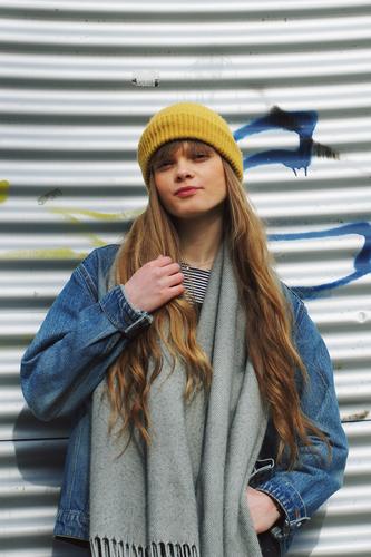 Portrait einer jungen Frau Mädchen Street lange Haare Mütze gelb blau blond Cool schön attraktiv Model hübsch Mensch streetstyle Streetlife Jeansjacke frontal