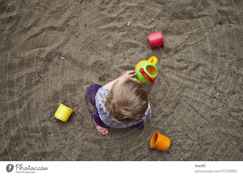 Kleinkind spielt im Sand I Sandkasten Spielen Spielplatz Kindheit Außenaufnahme Kinderspiel Vogelperspektive