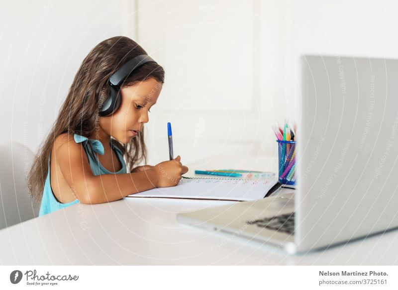 Kleines hispanisches Mädchen, das vor dem Laptop lernt. E-learning, zu Hause online lernen. Computer Kinder jung Video Schule Bildung E-Learning Lernen