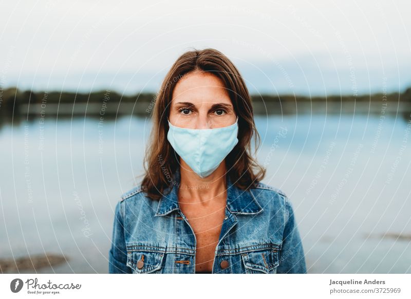 Frau trägt Mundschutz in der Corona Pandemie Maske Gesichtsmaske Schutz Coronavirus covid-19 COVID Virus Infektionsgefahr Corona-Virus Prävention Krankheit