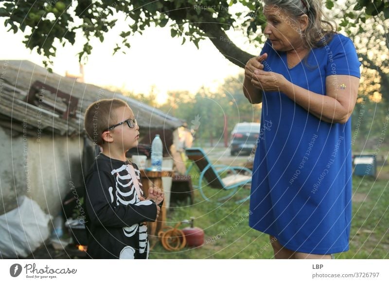 Frau spricht mit Kind, das ein Skelettkostüm trägt Porträt Liebe Wahrheit Vertrauen Gefühle Leben Kindheit Paar Familie & Verwandtschaft Großmutter Senior
