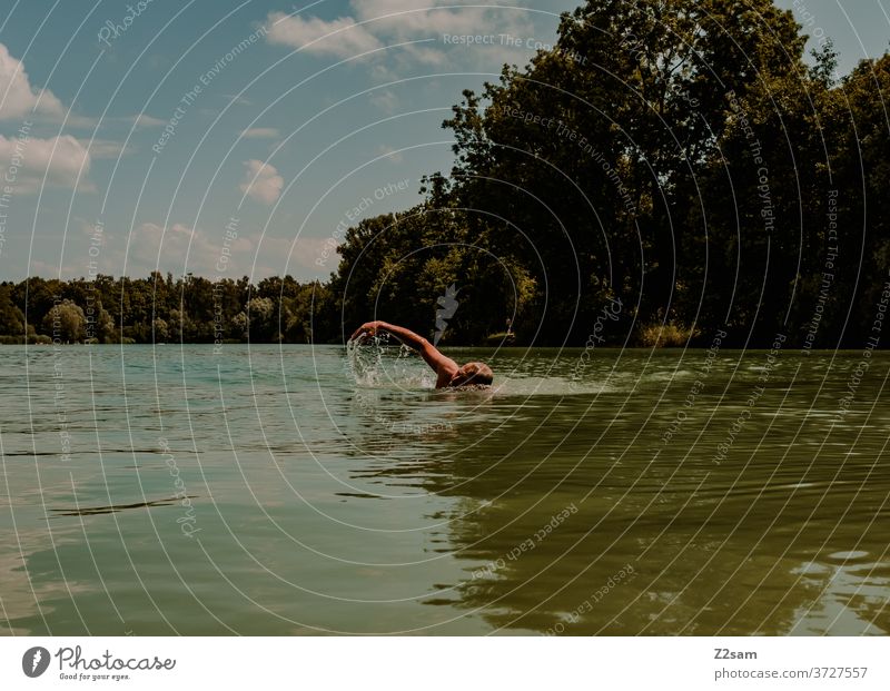 Rentner beim Kraulen im See schwimmen freizeit rentner rente sommer see gewässer wasser sport bewegung nasenklammer sportlich braun alter mann portrait