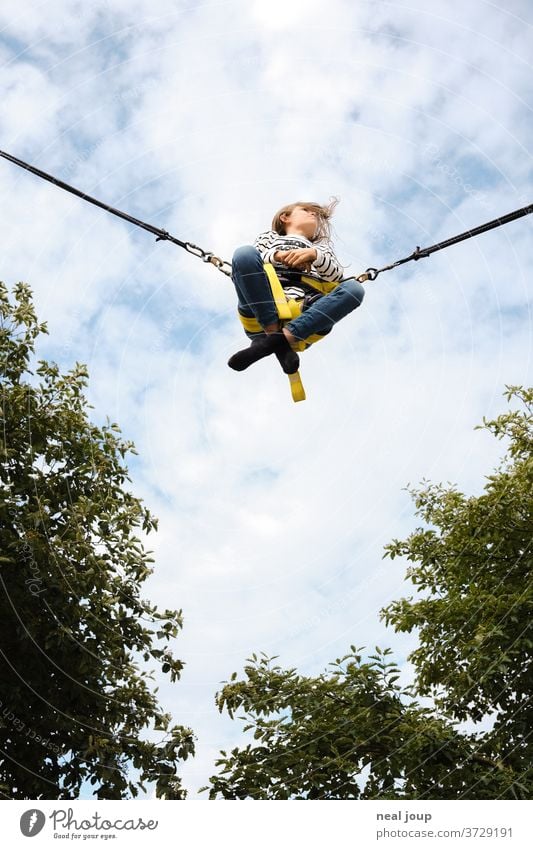 Mädchen fliegt in den Himmel – Rocket Bungee fliegen fröhlich frei Freiheit Leichtigkeit lässig Schneidersitz Freizeit Vergnügen Außenaufnahme Freizeit & Hobby