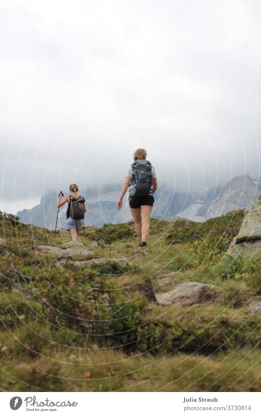 2 Frauen wandern in den Bergen Berge u. Gebirge steinig zwei Rucksacktourismus Rucksackurlaub wolkiger himmel Nebel kurze hose Sommer Sommerurlaub Außenaufnahme