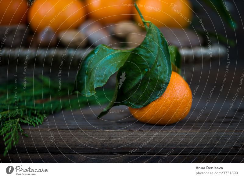 Nüsse, frische Klementinen oder Mandarinen im Korb und Weihnachtsbaumzweige auf braunem Holzhintergrund 2017 2018 Postkarte abstrakt Hintergrund schwarz