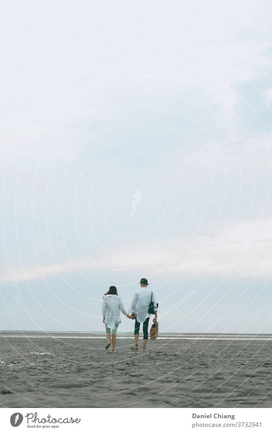 Paar zu Fuß auf dem Strand Verliebtheit verwandt stimmig Zuneigung Vertrauen Sandstrand Schönes Wetter Liebespaar Zusammensein Reisefotografie Blauer Himmel
