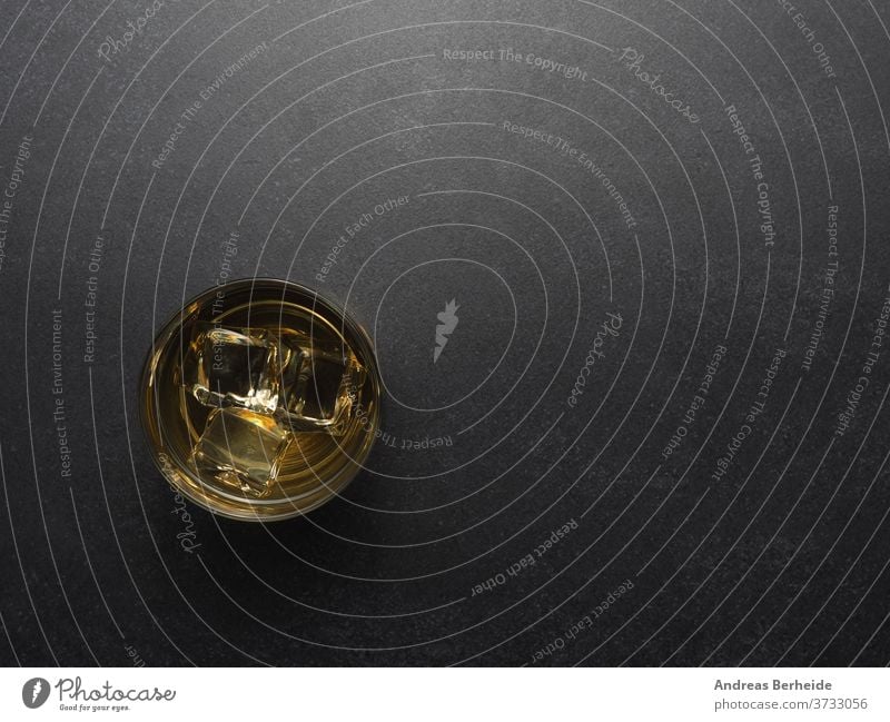 Glas Whiskey auf einem Tisch aus dunklem Stein Whisky kalt Single Steine Würfel golden Cognac Scotch Weinbrand altehrwürdig Hintergrund liquide Malz trinken