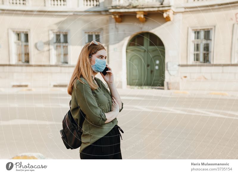 Junge Frau mit Maske telefoniert draußen in der Stadt 2020 Erwachsener schön blau Kaffee Kaukasier Kind Kindheit Großstadt Konzept Coronavirus covid-19