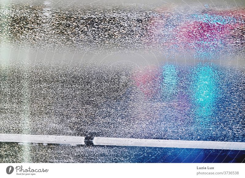 Asphalt, regennasse Fahrbahn mit Spiegelungen diverser Lichter Nässe Regen grau Fahrbahnmarkierung Fahrspur blau rot lila Reflexion & Spiegelung Straße Wasser