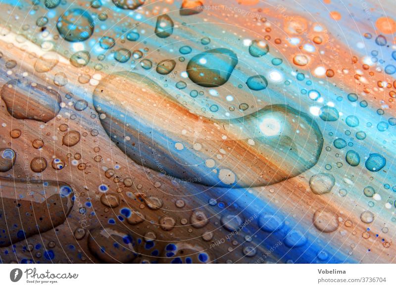 Regentropfen auf bunter Oberfläche regen regentropfen wasser wassertropfen wassernass naesse farbe braun blau orange gruen Tropfen Makroaufnahme Detailaufnahme