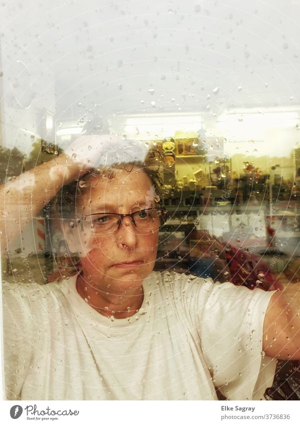 Nachdenklich schaut sie in den Regen.... Frau Mensch Gesicht trauriger blick nachdenklich Fensterscheibe