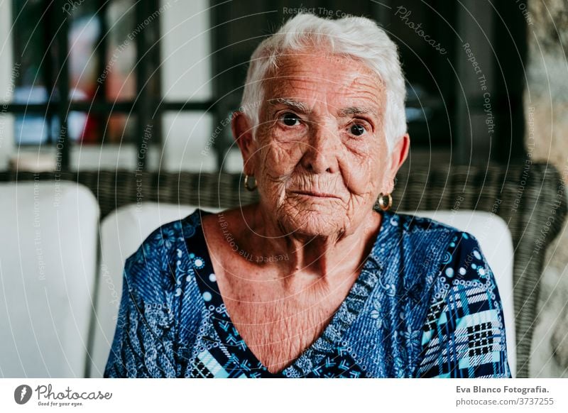 Porträt einer alten Dame in den 80er Jahren, die entspannt zu Hause sitzt. Frau älter heimwärts garrotte weiße Haare graue Haare mental Einsamkeit nachdenklich