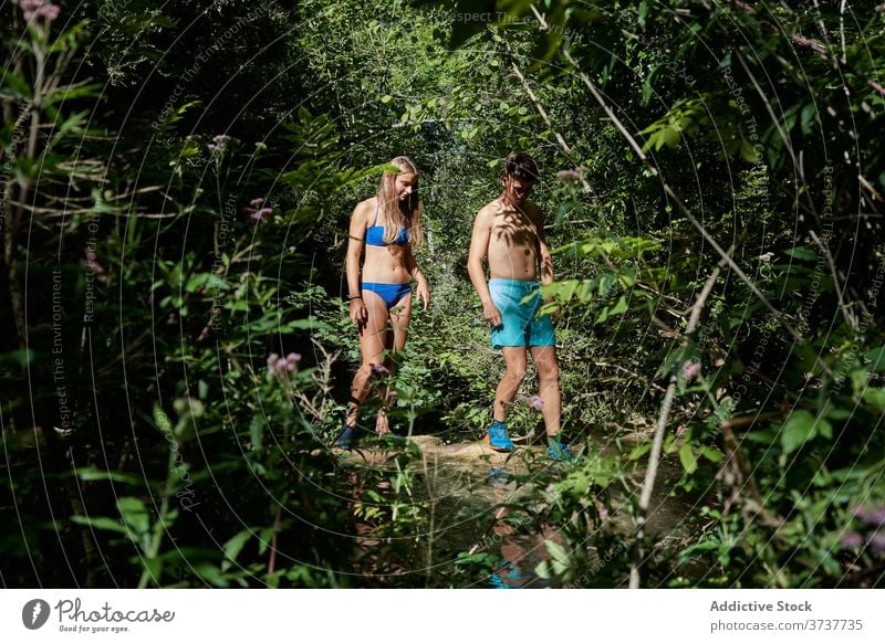 Reisendes Paar in der Nähe von See im Wald reisen sich[Akk] entspannen Zusammensein Badebekleidung Feiertag Sommer Teich Natur Gelassenheit Urlaub Sonnenlicht