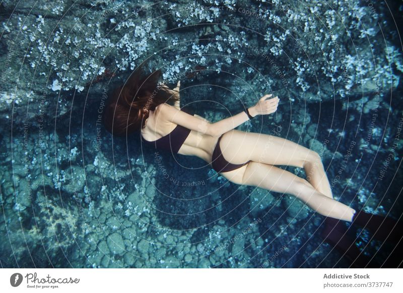 Frau schwimmt unter Wasser im Meer Sinkflug MEER Taucher Sommer schwimmen Urlaub Schutzbrille übersichtlich schlank Feiertag Aktivität Badebekleidung blau