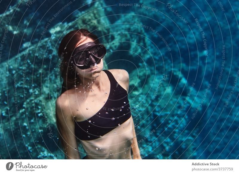 Junge Frau in Tauchermaske schwimmt unter Wasser Mundschutz Schutzbrille Schnorchel Tauchgerät schwimmen MEER Meer jung Sauberkeit durchsichtig Sinkflug